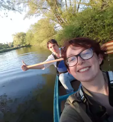A selfie, taken by Olivia, of her and a friend paddling in a boat.